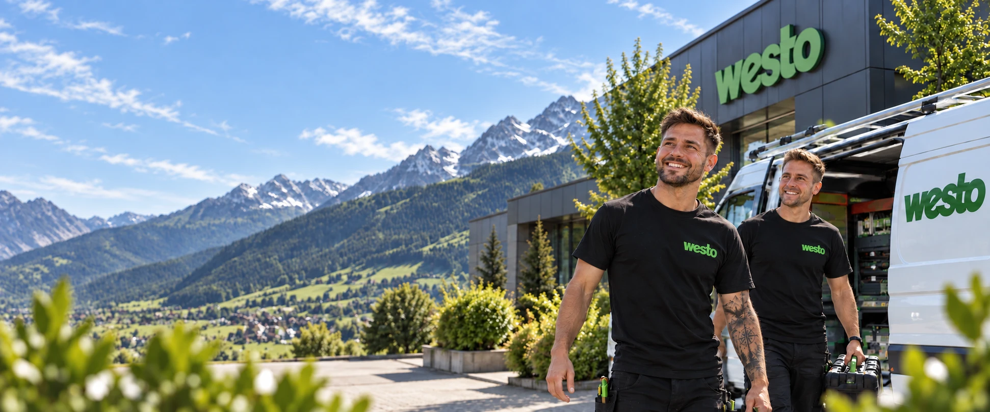 Zwei WESTO-Monteure mit Werkzeug vor dem Firmengebäude und dem Servicewagen, im Hintergrund die Berge
